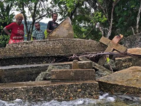 Island graves overseen by three people