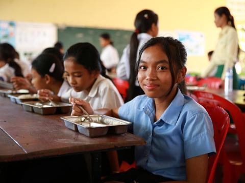 Chandy enjoyes her school meal in Cambodia