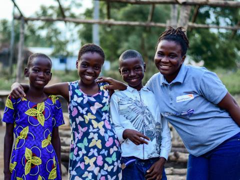 Group photo of Eyram, Bryan and Princess with WV education officer, Priscilla (right)