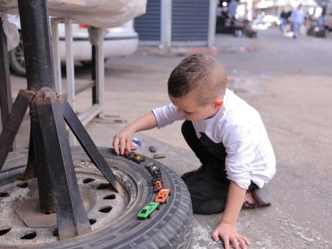 Child in West Bank plays with a toy car