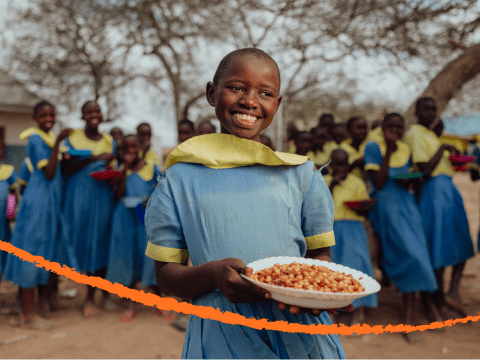 girl holding bowl of food at school feeding