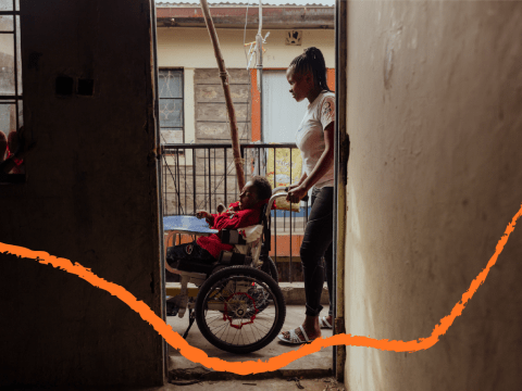 Child in wheelchair being pushed by care taker