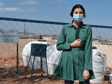 A girl poses in a dry landscape