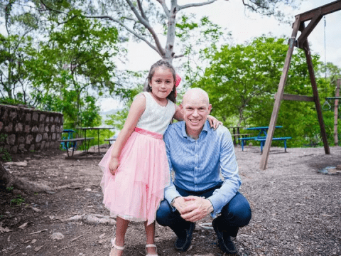 Andrew Morley squats with a young girl